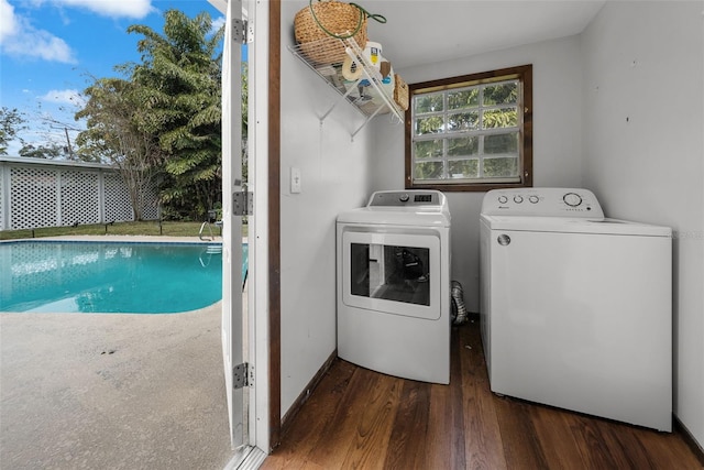 laundry area with dark hardwood / wood-style floors and washer and clothes dryer