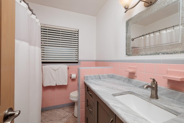 bathroom with vanity, tile patterned flooring, toilet, and tile walls