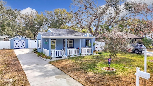 bungalow-style house with a storage shed, a front yard, and covered porch