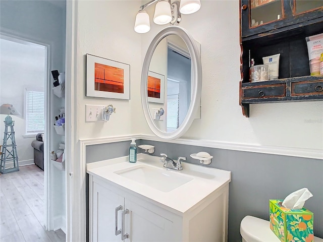 bathroom with vanity, hardwood / wood-style flooring, and toilet