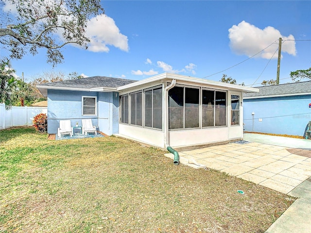 back of property featuring a patio, a sunroom, and a lawn