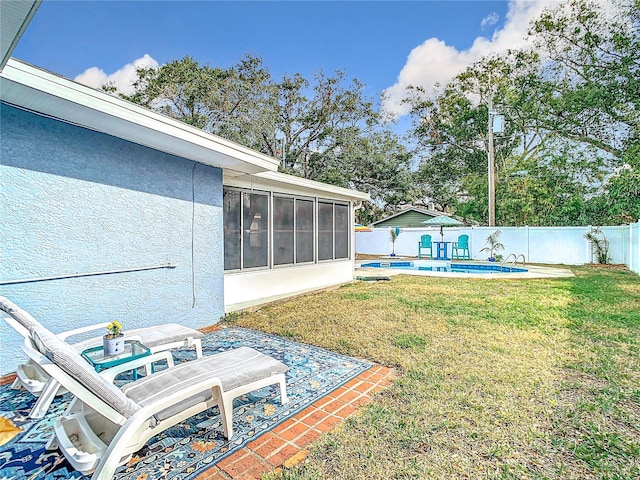 view of yard with a fenced in pool and a sunroom