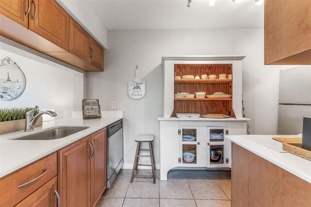 kitchen featuring dishwasher, fridge, sink, and light tile patterned flooring