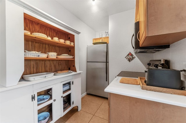 kitchen featuring stainless steel fridge and light tile patterned flooring