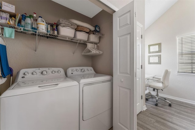 laundry area with light hardwood / wood-style floors and washer and dryer