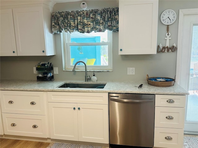 kitchen featuring sink, dishwasher, light stone counters, light hardwood / wood-style floors, and white cabinets