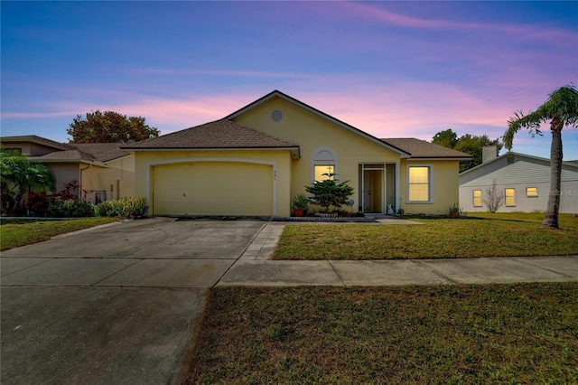 ranch-style home featuring a garage and a lawn