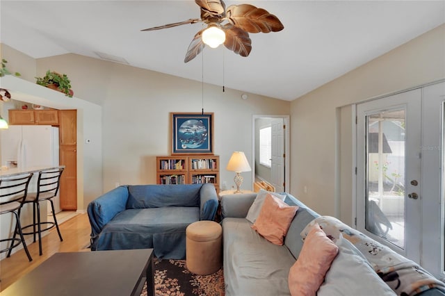 living room featuring light hardwood / wood-style flooring, vaulted ceiling, french doors, and ceiling fan