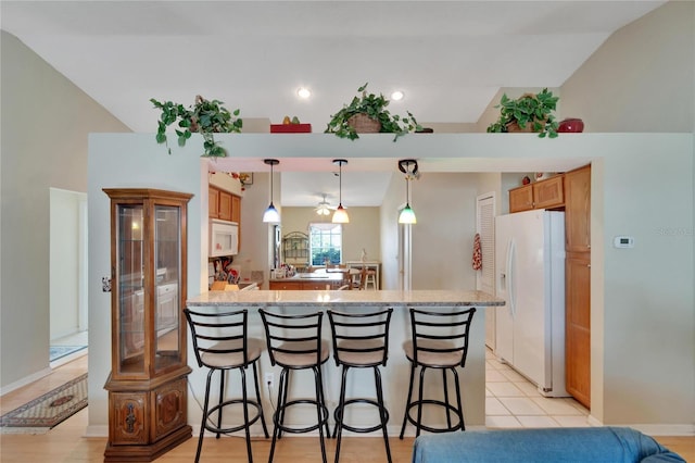 kitchen featuring white appliances, hanging light fixtures, high vaulted ceiling, a kitchen breakfast bar, and kitchen peninsula