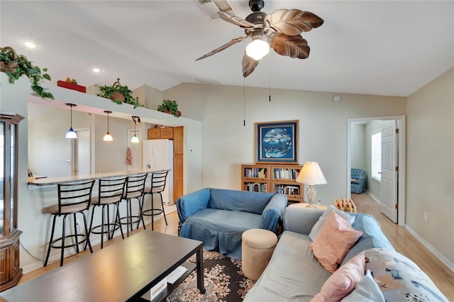 living room featuring ceiling fan, light hardwood / wood-style floors, and vaulted ceiling