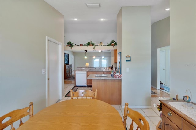 tiled dining room with sink and a high ceiling