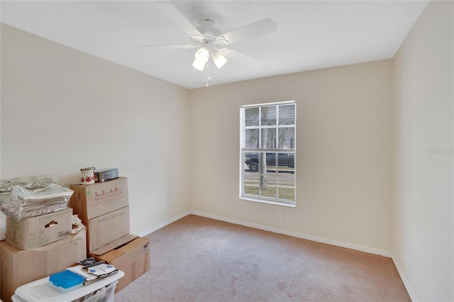 carpeted spare room with ceiling fan