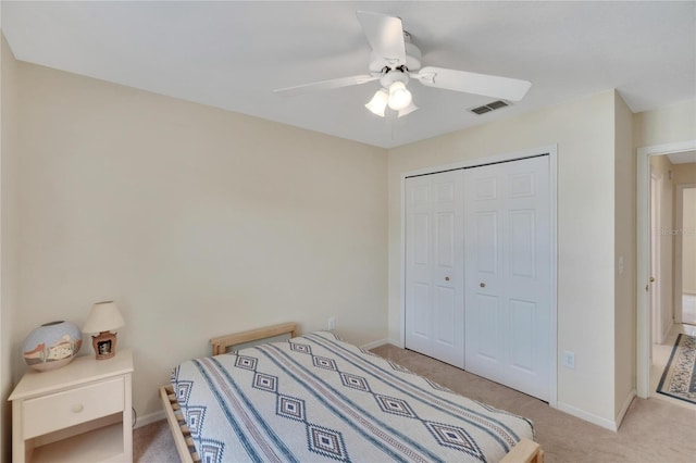 carpeted bedroom featuring a closet and ceiling fan