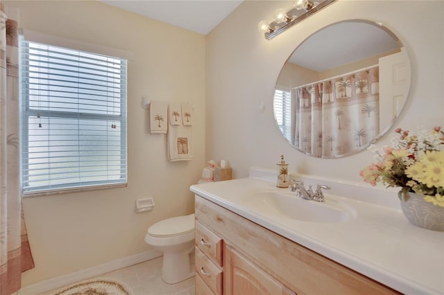 bathroom featuring tile patterned floors, toilet, vanity, and a wealth of natural light