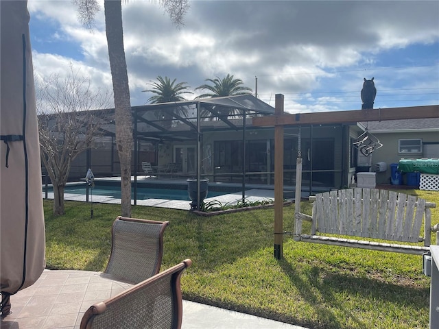 exterior space featuring a yard, a fenced in pool, a patio area, and glass enclosure