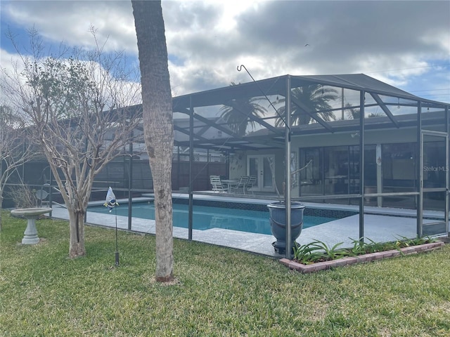 view of pool featuring a lanai, a patio area, french doors, and a lawn