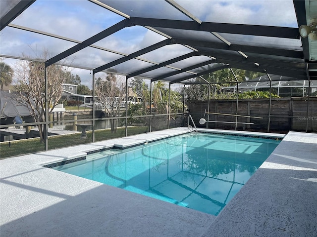 view of pool with a water view and glass enclosure