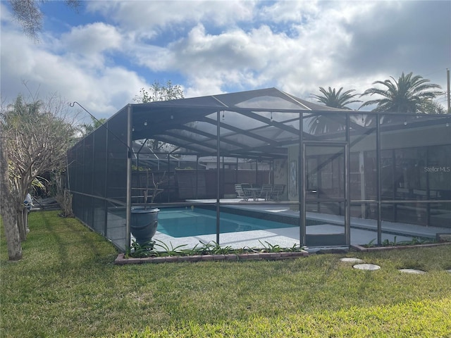 view of pool with a patio, glass enclosure, and a lawn