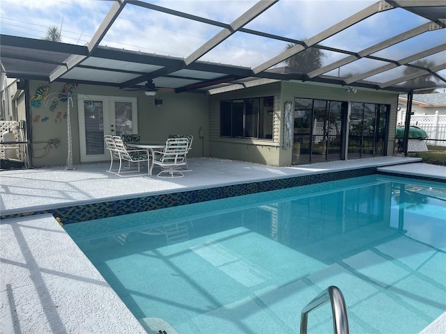 view of pool with a patio, ceiling fan, and glass enclosure