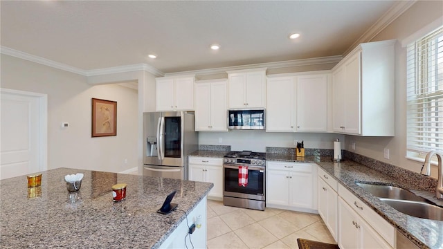 kitchen with dark stone countertops, sink, stainless steel appliances, and white cabinets