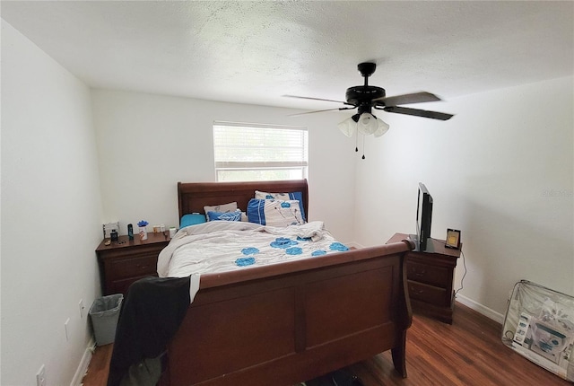 bedroom featuring a textured ceiling, dark wood-type flooring, and ceiling fan