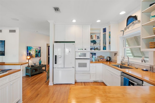 kitchen featuring butcher block counters, sink, white appliances, and white cabinetry