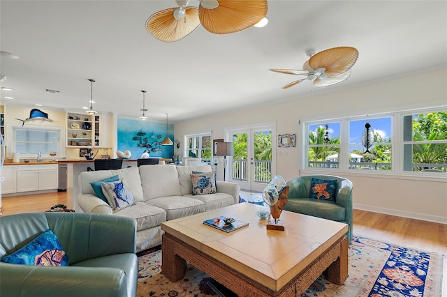 living room featuring french doors, sink, light hardwood / wood-style flooring, built in features, and ceiling fan