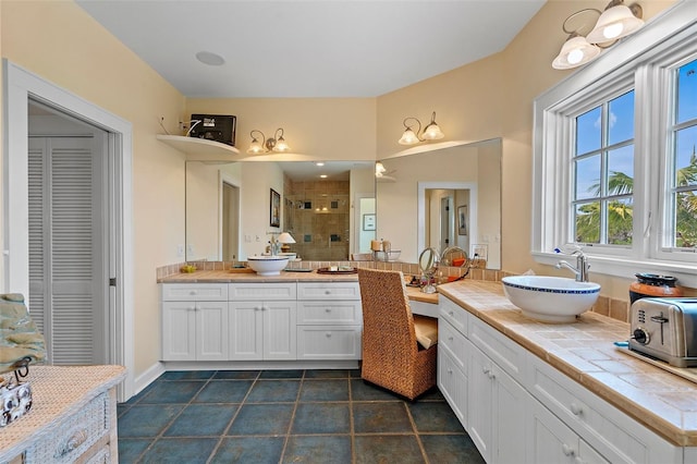 bathroom featuring tiled shower, vanity, and tile patterned floors