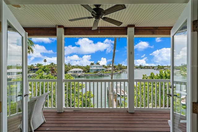 unfurnished sunroom with a water view and ceiling fan