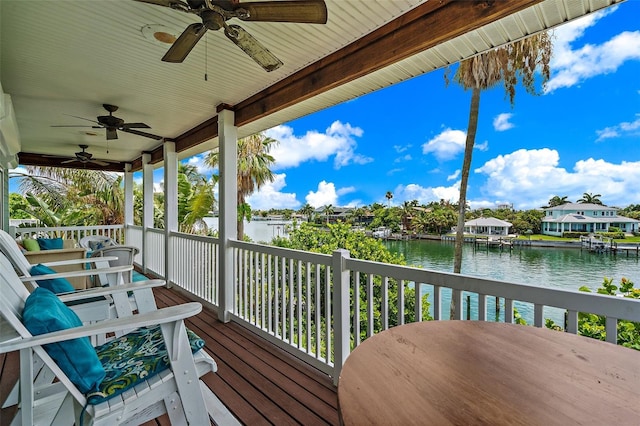 wooden deck featuring a water view and ceiling fan