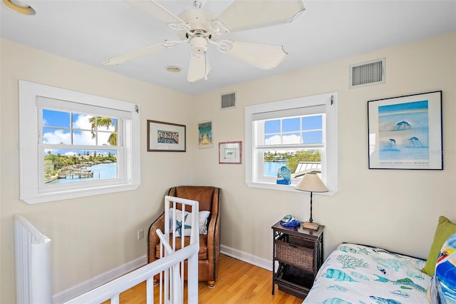 bedroom featuring multiple windows, ceiling fan, and light hardwood / wood-style floors