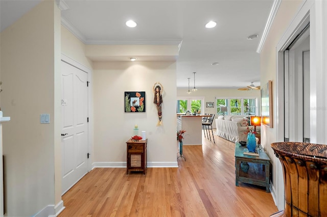 hall with ornamental molding and light wood-type flooring