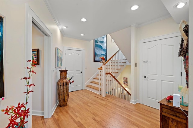 foyer entrance featuring ornamental molding and light hardwood / wood-style floors