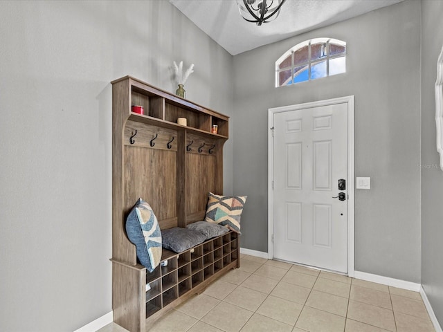 mudroom featuring light tile patterned flooring and a towering ceiling