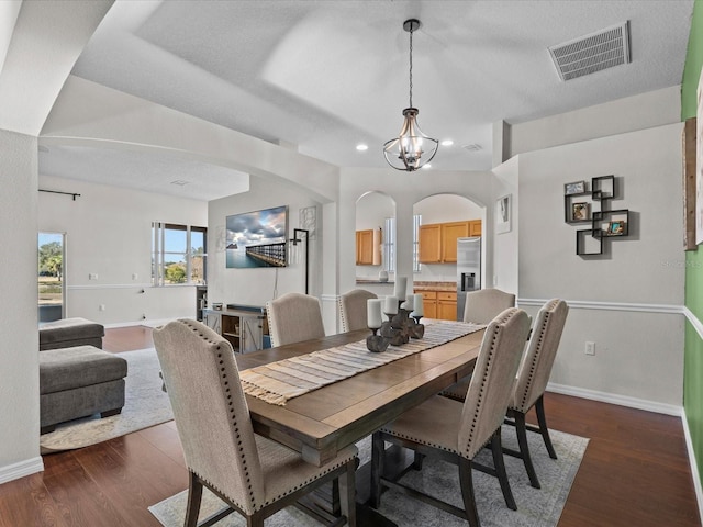 dining space with dark hardwood / wood-style floors and a chandelier