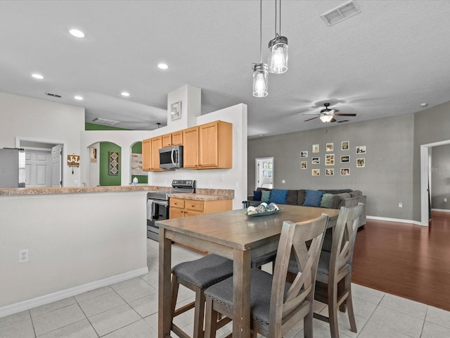 dining room with ceiling fan, a textured ceiling, and light tile patterned floors