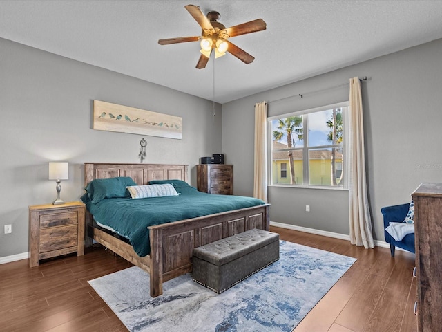 bedroom featuring a textured ceiling, dark wood-type flooring, and ceiling fan