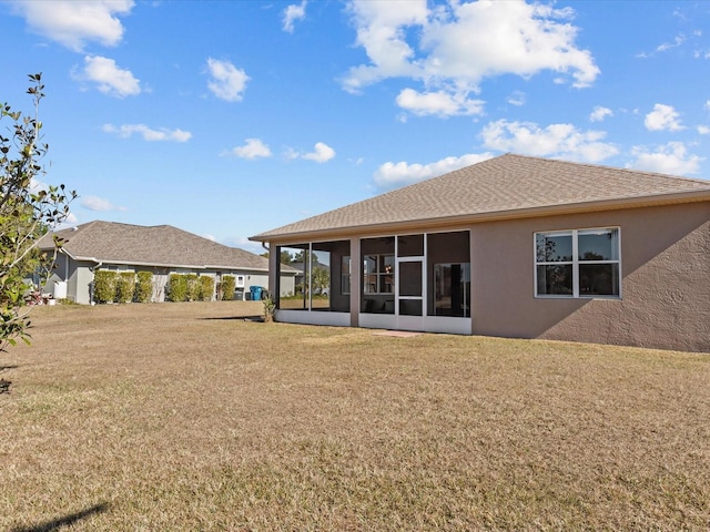 back of house featuring a yard and a sunroom