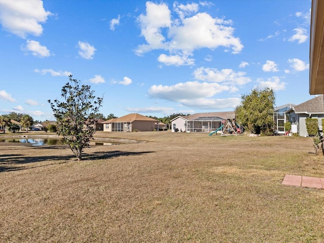 view of yard featuring a water view and a playground