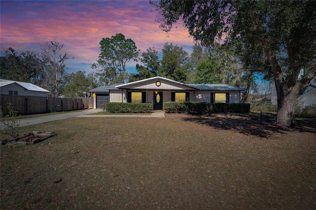 view of front of house with concrete driveway, an attached garage, and fence