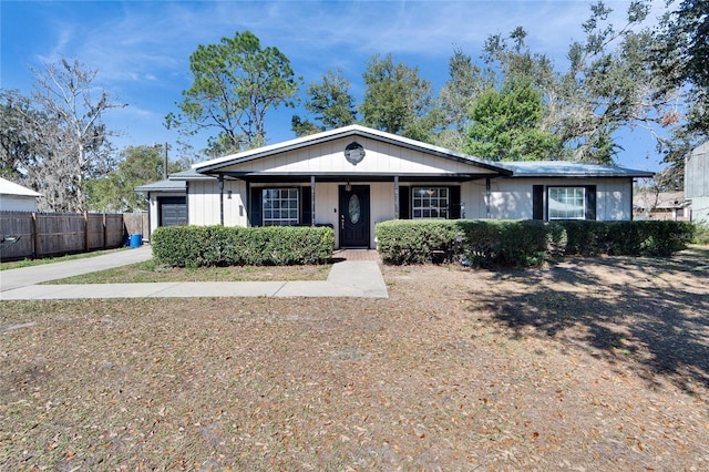 view of front of home with a garage, concrete driveway, and fence