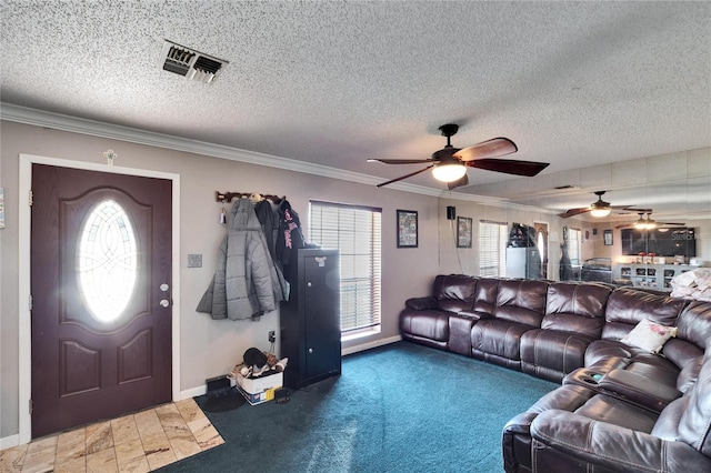 living room with ceiling fan, ornamental molding, and a textured ceiling