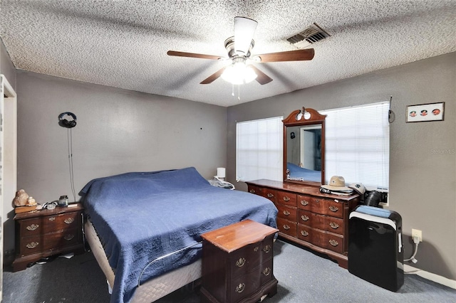 carpeted bedroom featuring ceiling fan and a textured ceiling