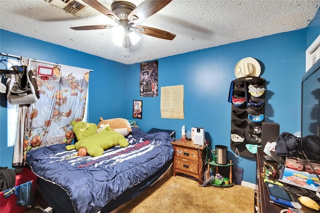 bedroom with ceiling fan, carpet flooring, and a textured ceiling