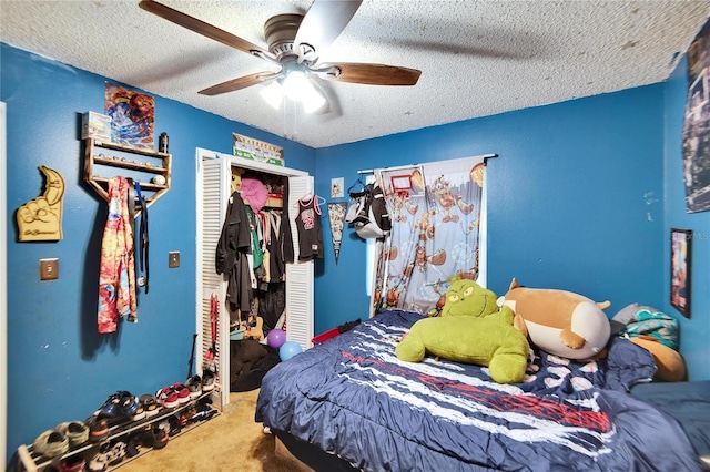 carpeted bedroom with ceiling fan, a closet, and a textured ceiling