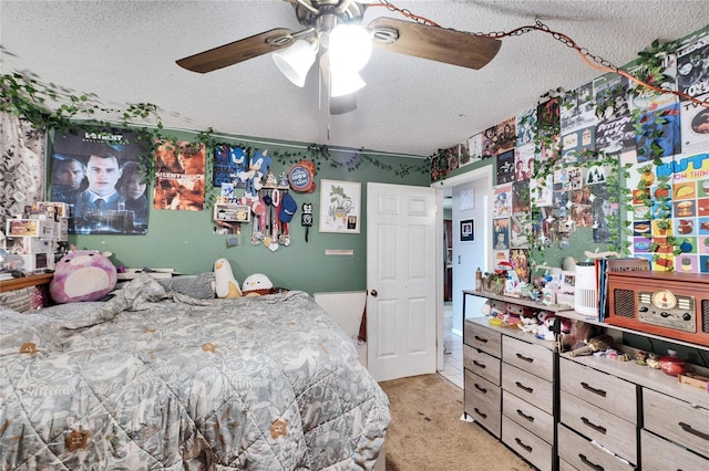 bedroom with ceiling fan, light colored carpet, and a textured ceiling