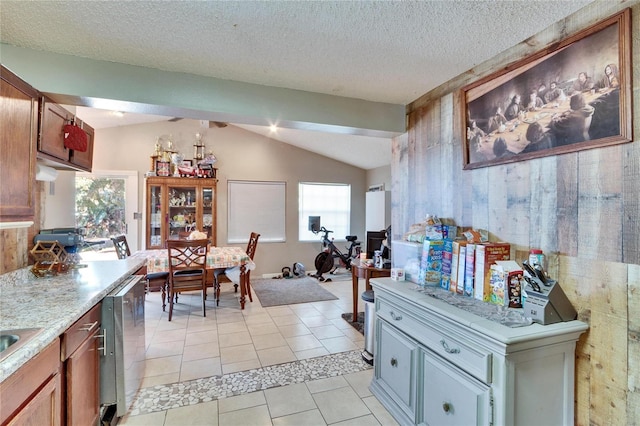 kitchen featuring vaulted ceiling, a textured ceiling, and light tile patterned floors