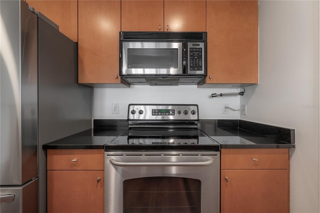 kitchen featuring stainless steel appliances and dark stone countertops