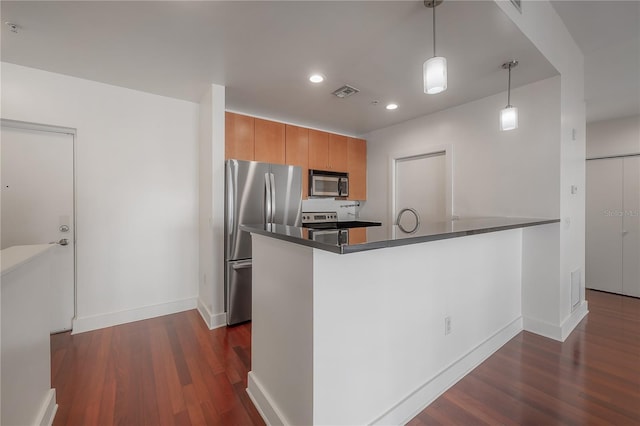 kitchen featuring pendant lighting, dark hardwood / wood-style floors, kitchen peninsula, and appliances with stainless steel finishes