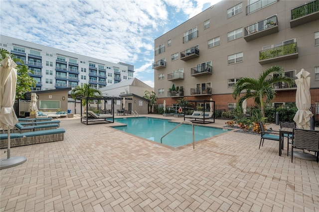 view of pool featuring a pergola, a patio area, and a wall mounted AC